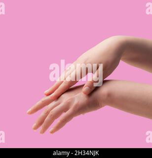 Weibliche Hände und feuchtigkeitsspendende Creme auf weißem Hintergrund Stockfoto