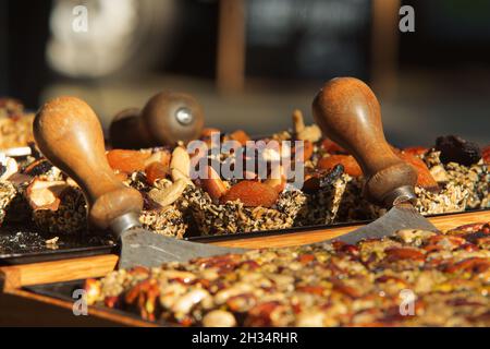 Süße Riegel aus natürlichen Zutaten, verschiedenen Trockenfrüchten, Nüssen, Samen und Honig auf dem Bauernmarkt. Kleine Unternehmen und lokale Stadt sho Stockfoto