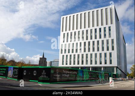 Slough, berkshire, Großbritannien. 25. Oktober 2021. Das neue Bürogebäude für zukünftige Arbeiten in Slough ragt über der römisch-katholischen Kirche von St. Ethelbert auf. Das Stadtzentrum in Slough verändert sich rasant. Rund um die Stadt, die an der Crossrail-Schnellverbindung liegt, die heute als Elizabeth Line nach London bekannt ist, werden neue Bürogebäude und Apartments gebaut. Quelle: Maureen McLean/Alamy Stockfoto