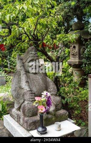 Eine Statue von Ebisu, einem der sieben Glücksgötter, im Toyokawa Inari Betsuin Tempel in Asakusa, Tokio, Japan. Der buddhistische Tempel ist Teil der Soto Zen Sekte und beherbergt die Gottheit Toyokawa Dakinishinten, aber auch bekannt für die Tausenden von Fuchsstatuen. Stockfoto