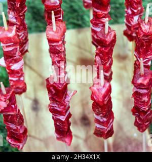 Holzbrett mit der traditionellen -arrosticini abbruzzesi-: Spieße von Schafsfleisch Stockfoto