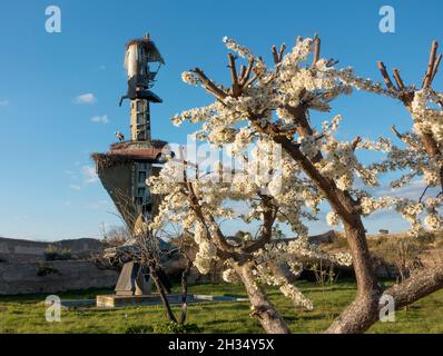 Blüten auf einem Baum stehen im Gegensatz zur Installation Kunstskulptur des verstorbenen deutschen Künstlers Wolf Vostell im Vostell-Malpartida Museum bei Cá Stockfoto