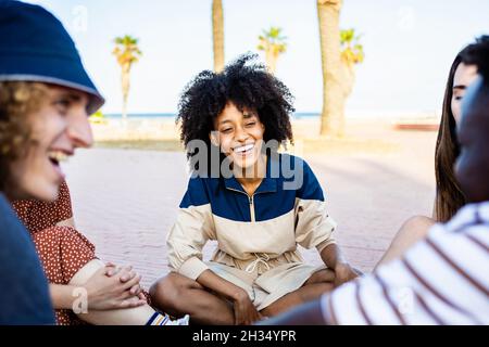 Gemischte Renngruppe von jungen Leuten, die im Freien miteinander reden und Spaß haben Stockfoto