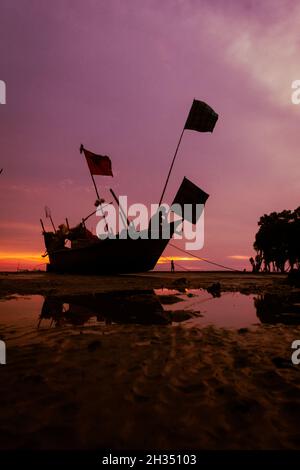 Fischerboot wartet auf Flut bei Sonnenuntergang. Stockfoto