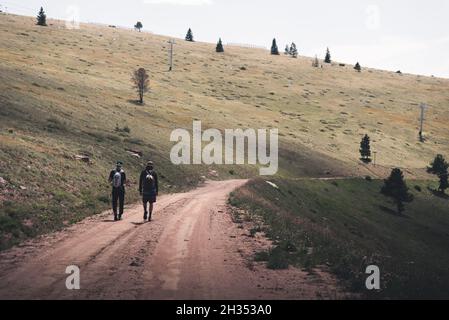 Männer, die auf einer unbefestigten Straße auf Vail, Mountain in Colorado gehen. Stockfoto