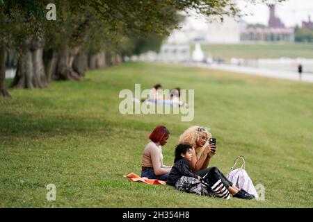 Washington, USA. Oktober 2021. Am 25. Oktober 2021 sitzen Menschen auf einem Rasen in der National Mall in Washington, DC, USA. Die Berater der US-amerikanischen Food and Drug Administration (FDA) werden am Dienstag zu einem wichtigen Treffen darüber zusammentreffen, ob der Impfstoff Pfizer-BioNTech COVID-19 für Kinder im Alter von 5 bis 11 Jahren empfohlen werden soll, da Experten vorhersagten, dass jüngere Kinder Anfang November für den Impfstoff in Frage kommen werden. Kredit: Ting Shen/Xinhua/Alamy Live Nachrichten Stockfoto