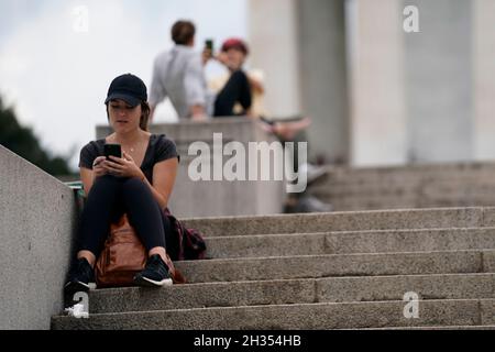 Washington, USA. Oktober 2021. Eine Frau sitzt am 25. Oktober 2021 auf den Stufen des Lincoln Memorial in Washington, DC, USA. Die Berater der US-amerikanischen Food and Drug Administration (FDA) werden am Dienstag zu einem wichtigen Treffen darüber zusammentreffen, ob der Impfstoff Pfizer-BioNTech COVID-19 für Kinder im Alter von 5 bis 11 Jahren empfohlen werden soll, da Experten vorhersagten, dass jüngere Kinder Anfang November für den Impfstoff in Frage kommen werden. Kredit: Ting Shen/Xinhua/Alamy Live Nachrichten Stockfoto