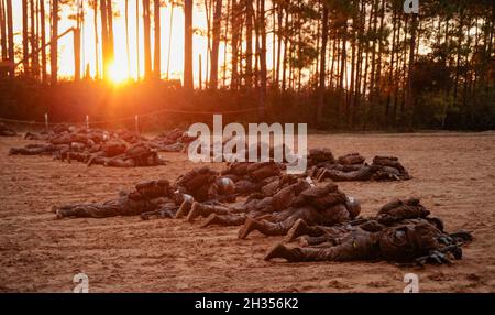 Rekruten mit Papa Company, dem 4. Rekrut Training Bataillon, ziehen während des Crucible als Trupps zusammen, während die Sonne über dem Marine Corps Recruit Depot Parris Island, S.C., aufgeht 22. Oktober 2021. Während der 24 Einzelveranstaltungen von The Crucible werden Rekruten in Trupps aufgeteilt, um sich Herausforderungen zu stellen, die ihre körperliche Stärke und Teamfähigkeit, die sie während des Trainings entwickelt haben, auf die Probe stellen. (USA Marine Corps Foto von Sgt. Dana Beesley) Stockfoto