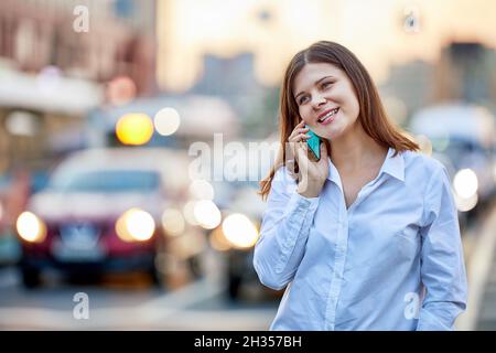 Glückliche Frau telefoniert in der Nähe der Autobahn. Stockfoto