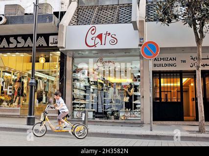 Ein libanesischer Junge fährt mit einem dreirädrigen Fahrrad entlang der Hamra Street im Stadtteil Hamra in Beirut, Libanon. Ein Tag war für Fußgänger und Fahrradfahrer vorgesehen, die nur zeigten, wie die beliebte Straße ohne den Verkehr wäre. Stockfoto