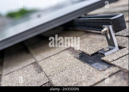 Schiene, Halterung und Anker an einem Solarpanel, das auf einem Asphaltschindeldach installiert ist Stockfoto