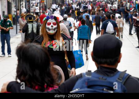 Nicht exklusiv: Eine Person, die als Schädel auf dem Blumenmarkt von Cempasuchil verkleidet ist, und Dekorationen auf der Reforma Avenue im Rahmen der Feierlichkeiten zum Tag der Toten. Stockfoto