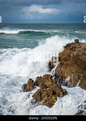 Riesige Wellen schlagen unter einem brütenden Himmel auf eine felsige Küste. Sievers Point (Sieverspunt) Hermanus. Whale Coast. Overberg. Westkap. Süd-Afro