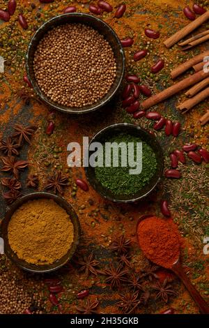 Gewürzkonzept die Mischung aus roten Bohnen, Paprika, Cayenne, Puder, Kümmel, Und grüne Bohnen auf den dunkelschwarzen Boden gelegt. Stockfoto