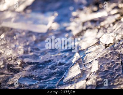 Nahaufnahme von Eisstücken auf gefrorenem See oder Fluss. Zerschmettert von rissem Eis in der Nähe. Gebrochenes Eis auf dem See. Winterhintergrund. Stockfoto