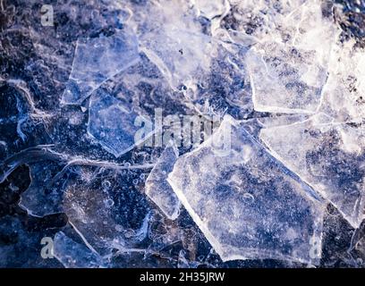 Nahaufnahme von Eisstücken auf gefrorenem See oder Fluss. Zerschmettert von rissem Eis in der Nähe. Gebrochenes Eis auf dem See. Winterhintergrund. Stockfoto