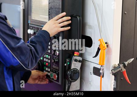 Worker passt die Parameter der CNC-Maschine an. Selektiver Fokus. Stockfoto