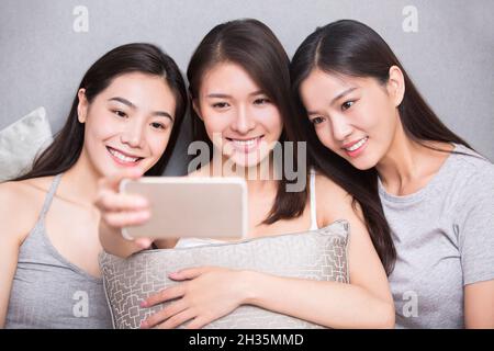 Drei beste Freunde, die Selfies auf einem Mobiltelefon machen Stockfoto