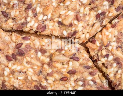 Nahaufnahme von Crunchy knusprigem selbstgebackenem Brot. Gesunder Snack. Getreide-Flachs, Sesam und Sonnenblumenkerne. Nahaufnahme der flachen Lay-Ansicht. Stockfoto