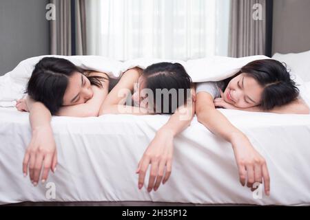 Drei beste Freunde ruhen sich auf dem Bett aus Stockfoto