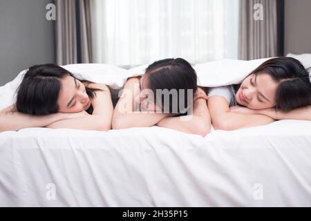 Drei beste Freunde ruhen sich auf dem Bett aus Stockfoto