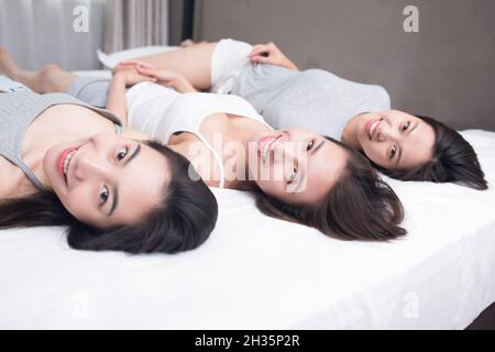 Drei beste Freunde ruhen sich auf dem Bett aus Stockfoto