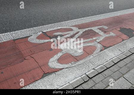 Das weiße Fahrradsymbol wurde auf der roten Fahrradspur lackiert. Stockfoto