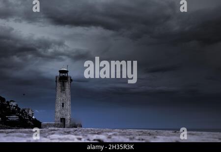 Temps menaçant sur un phare de mer méditerranée. Stockfoto