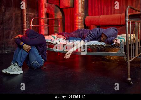 Drogensüchtiger Mann und Frau schlafen hoch in den, grunge Platz Interoir auf Hintergrund. Suchtproblem, ewige Depression von Junky-Leuten Stockfoto