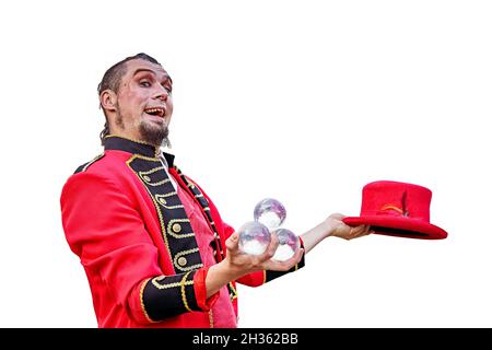 Bärtiger Mann in rotem Anzug, der Kristallkugeln hält, während er einen roten Hut in der Hand hält. Stockfoto
