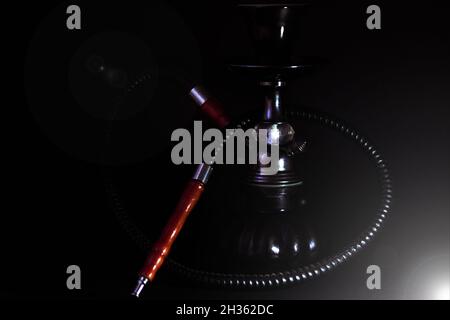 Kleine schwarze Shisha auf schwarzem Hintergrund mit einem Streulicht. Stockfoto