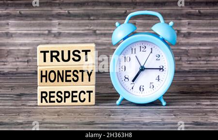Holzblöcke mit den Worten VERTRAUEN, EHRLICHKEIT, RESPEKT, auf einem hölzernen Hintergrund. Stockfoto