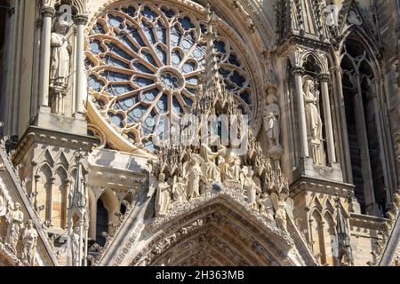 Nahaufnahme der reich verzierten mittelalterlichen Kathedrale Notre Dame de Reims in Frankreich, mit hoher gotischer Architektur, mit seinem zentralen Rosenfenster Stockfoto