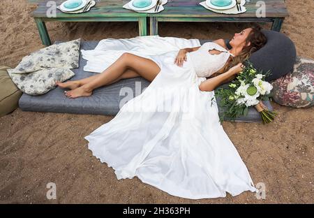 28. August 2016 Weißrussland. Zaslavskoe-Reservoir. Die Braut liegt auf einem Kopfkissen-Bett am Strand. Urlaubs- und Erholungskonzept. Stockfoto