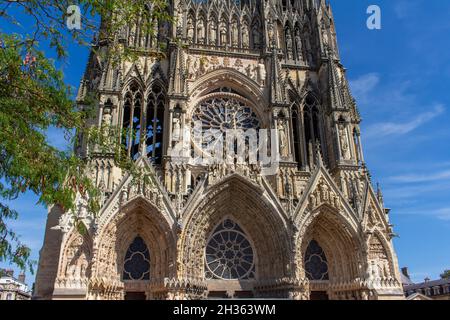 Nahaufnahme der reich verzierten mittelalterlichen Kathedrale Notre Dame de Reims in Frankreich, mit hoher gotischer Architektur, mit seinem zentralen Rosenfenster Stockfoto