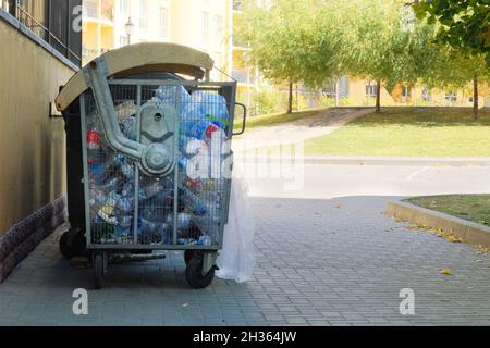 Plastikflaschen werden in einem Behälter gesammelt, der zum Recycling geschickt wird. Müllcontainer, die in der Stadt voll mit Müll sind. Stockfoto