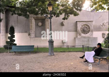 FRANKREICH. PARIS (75) 4. BEZIRK. DAS VIERTEL LE MARAIS. EIN JUNGE SITZT AUF DEM GEORGES-CAIN-PLATZ Stockfoto