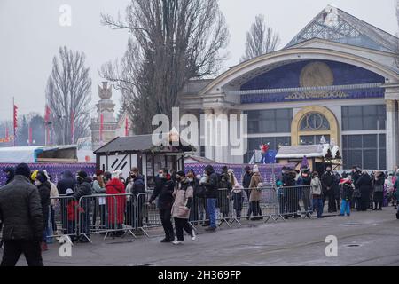 Kiew, Ukraine - 12.20.2020 Menschenmassen in schützenden Gesichtsmasken stehen in einer langen Schlange, um in die Eisbahn der Stadt zu gelangen. Stockfoto