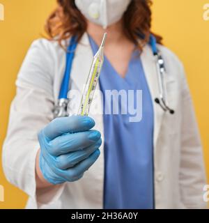 Eine Ärztin hält ein Quecksilberthermometer in der Hand. Medizinisches Instrument zur Messung der Körpertemperatur, Studio-Hintergrund Stockfoto