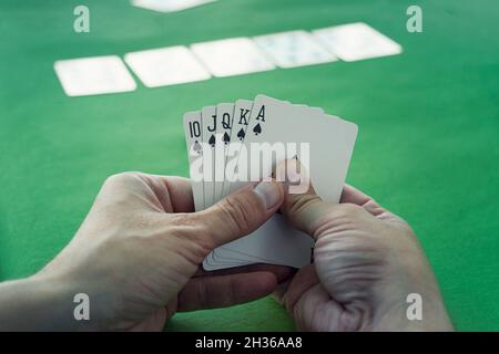 Royal Flush ist die beste Gewinnkombination im Poker. Gewinnen im Casino. Glück im Spiel. Karten in der Hand eines Mannes auf dem Hintergrund einer Ca Stockfoto