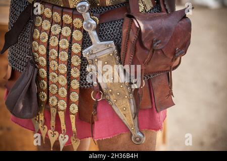 Centurion umgürtet einen Pugio, einen Dolch, der von römischen Soldaten als Seitenarm verwendet wird. Historische Reenactment Stockfoto