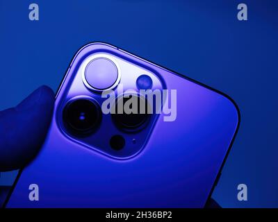 POV männliche Hand hält neueste Apple Computers iPhone 13 Pro Smartphone zeigt die Dreifachkamera auf der Rückseite Stockfoto