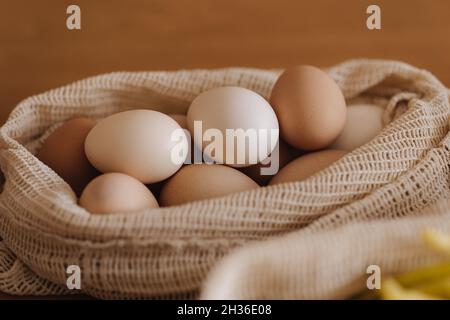 Eier in Leinenlebensmittelbeutel. Eier von Öko-Farm. Baumwollbeutel auf Holztisch. Zero Waste Shopping-Konzept. Kunststoffartikel Stockfoto