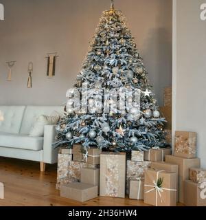 Klassisches zimmer mit einrichtung zum weihnachtsfest im Innenbereich. Weihnachtsbaum mit Gold- und Silberschmuck. Ein großer wunderschön dekorierter Weihnachtsbaum mit g Stockfoto