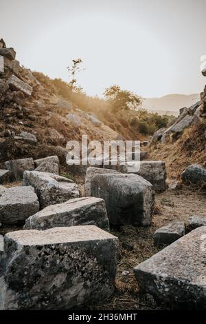 Vertikale Aufnahme von Felsen am Hang gegen einen hellen Sonnenuntergang Stockfoto