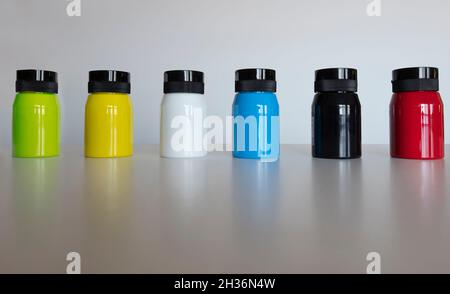 Sechs Jars mit verschiedenen Farben isoliert auf klarem Hintergrund. Acrylfarben. Künstlerisches Studio. Kreativität und Designoobjekte. Stockfoto