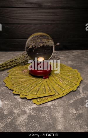 Magische Tarot-Karten, die auf dem Tisch um die Kristallkugel verteilt sind, zum Ritual Stockfoto