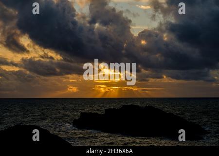 Ein dramatischer Sonnenuntergang vor der Küste auf Ynys Llandwyn auf Anglesey, North Wales, Großbritannien Stockfoto