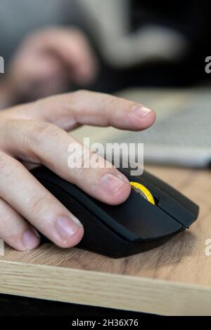 Geschäftsmann in elegantem Anzug und mit Computermaus in Nahaufnahme am Schreibtisch im Büro. Geld verdienen online. Geld auf Klicks. Werbung auf der Inter Stockfoto