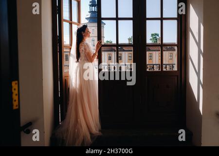 Eine elegante Braut auf dem Balkon eines alten Schlosses in der Stadt Nesvizh. Stockfoto